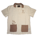 👕 Camisa de manga corta color marfil con textura estilo lino marca Malibu by Drill Clothing Co. Cuello y dos bolsillos de parche en color marrón. Bordados de hongos marrones en pecho y bolsillo
